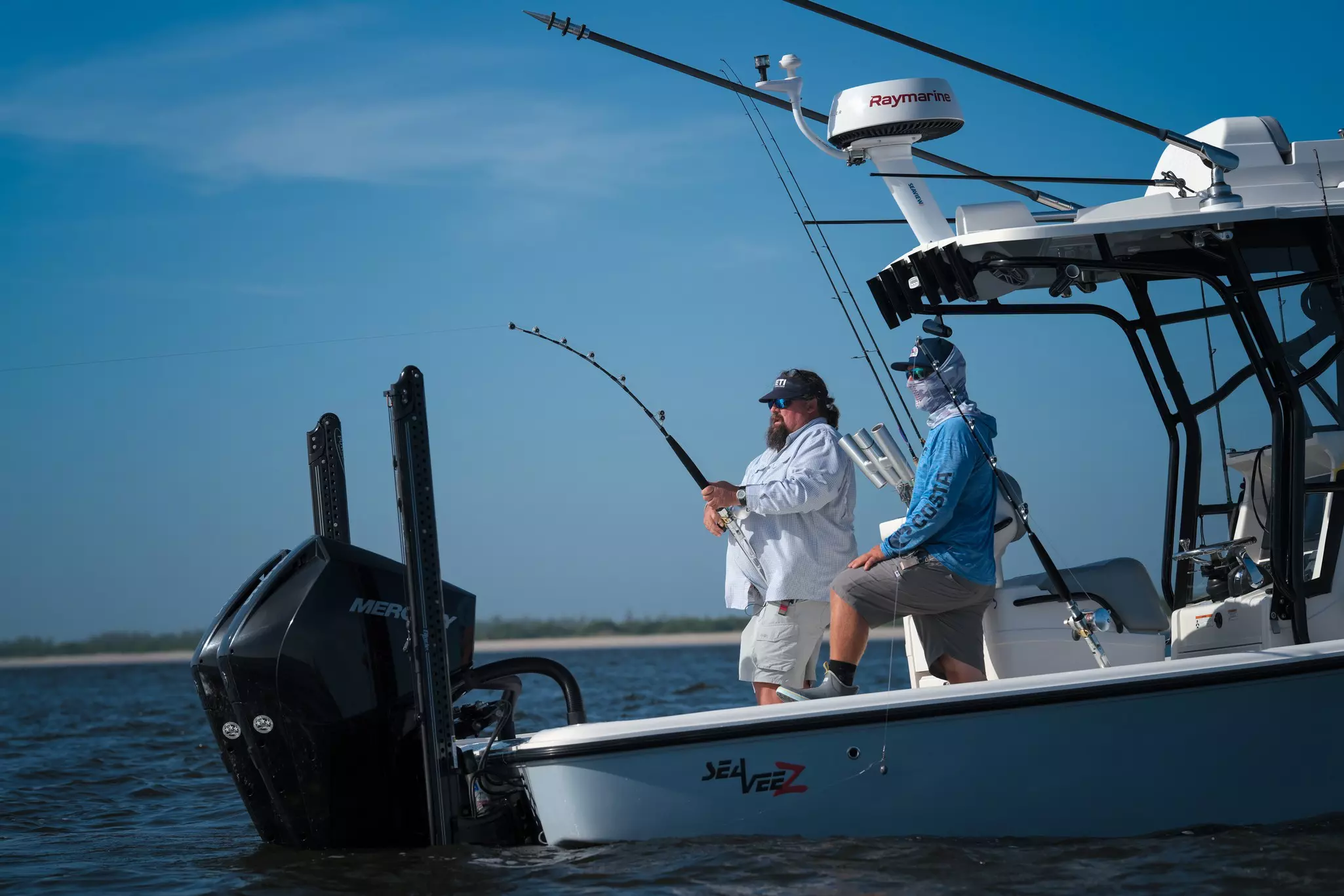 Fishermen on a boat in the ocean, with a Raymarine radar shown on top of the boat