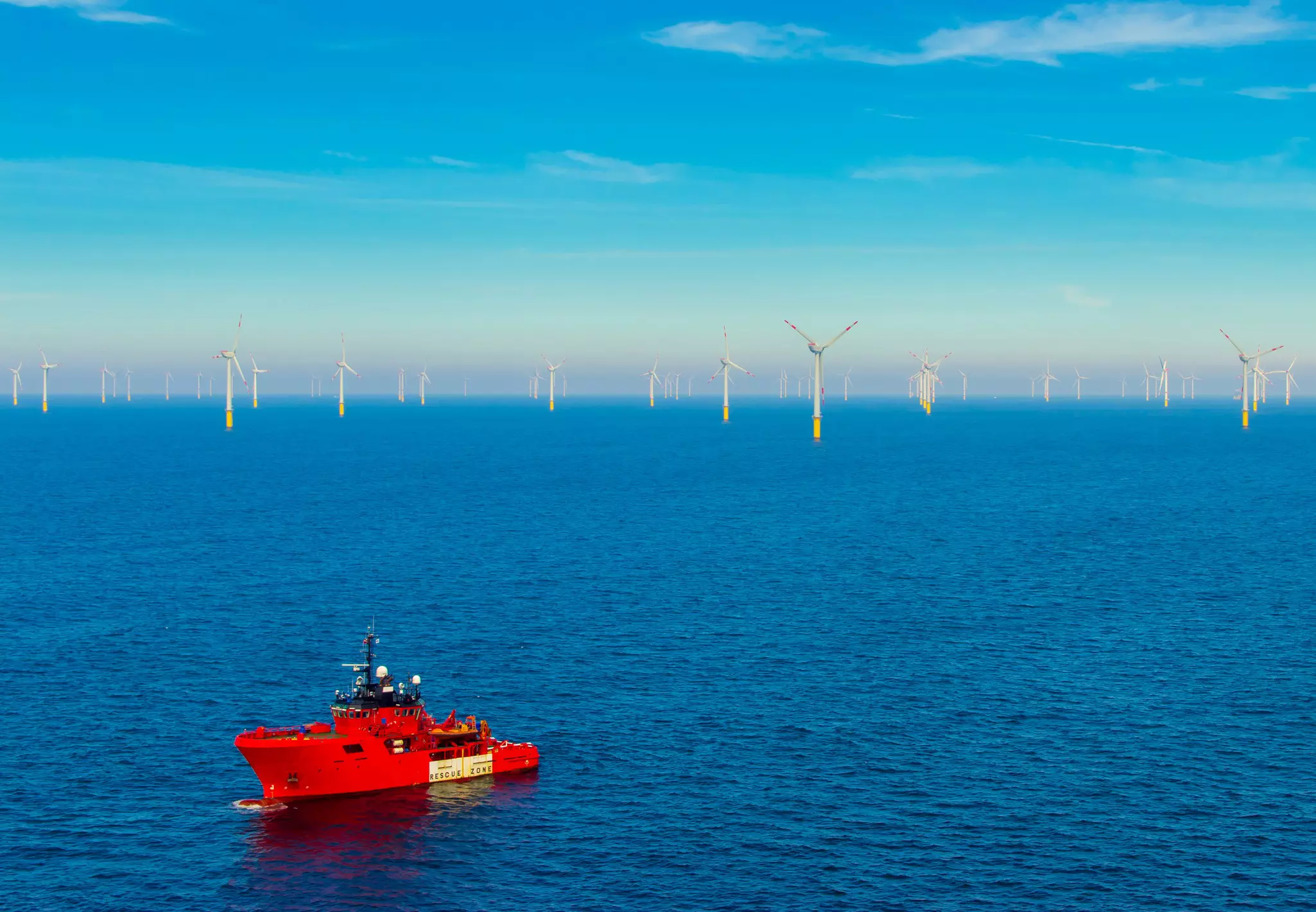 Offshore patrol vessel with wind farm in the background