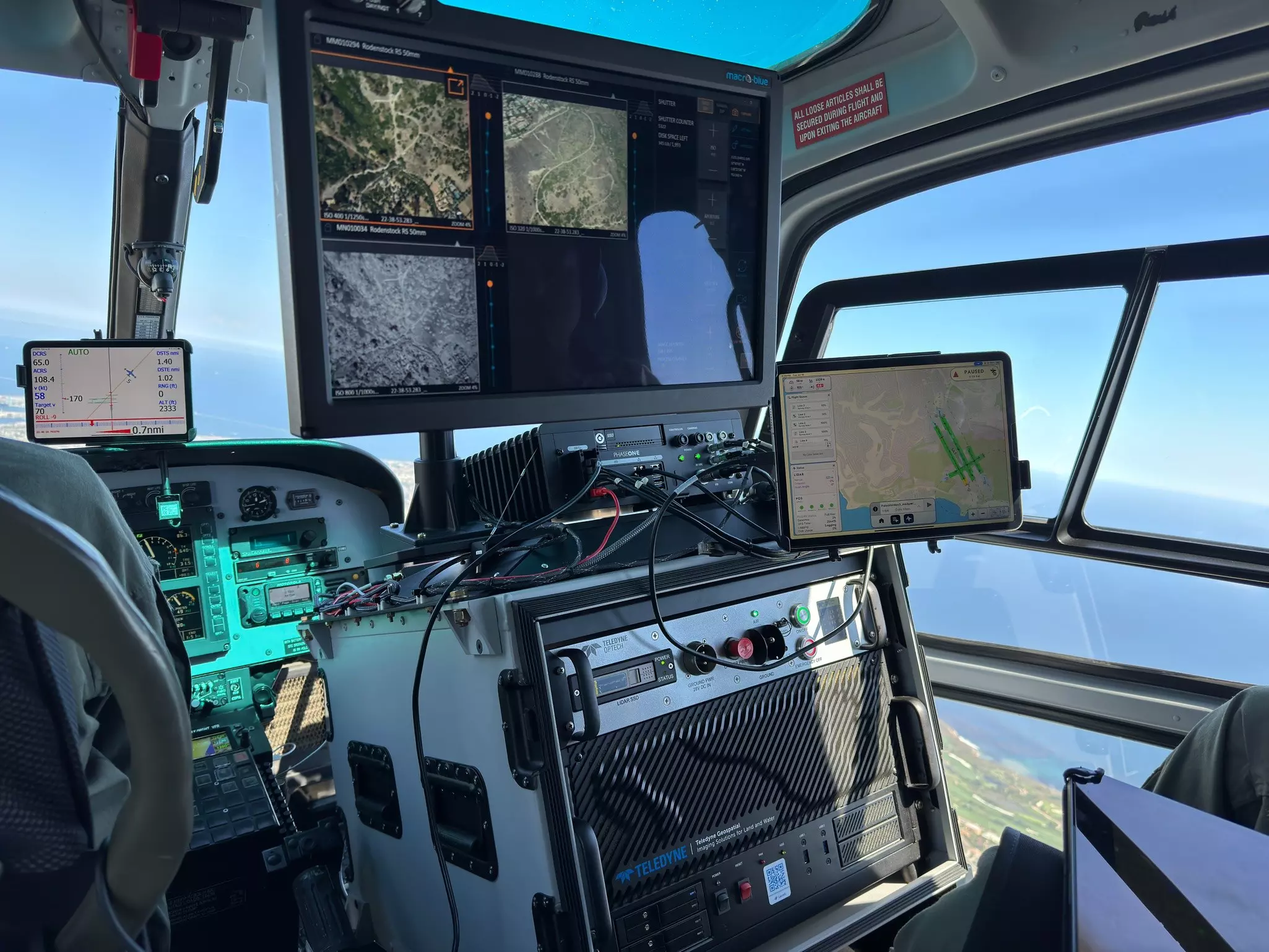Helicopter cockpit with surveillance screens and coastal view 