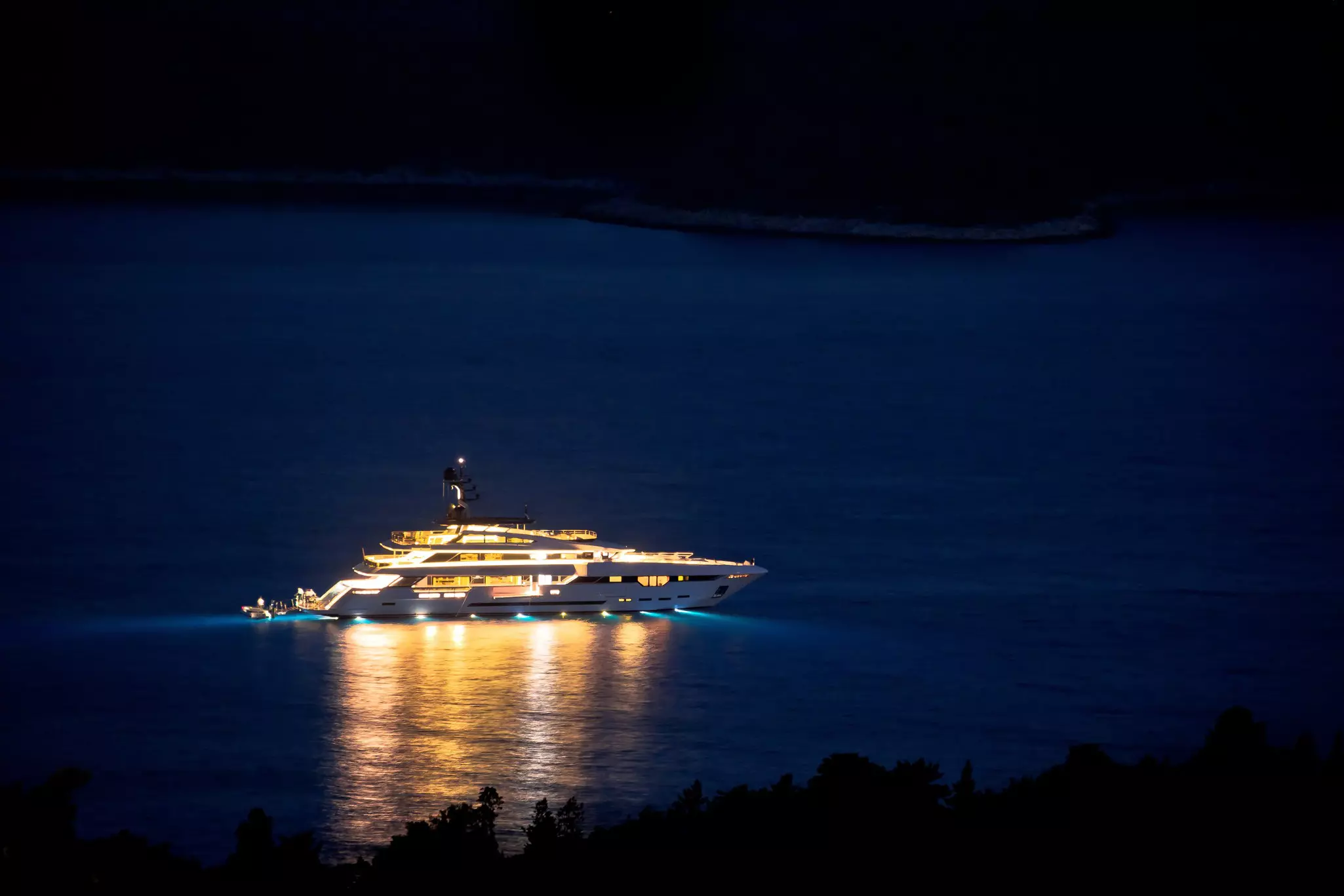 Superyacht sailing at night with lights on